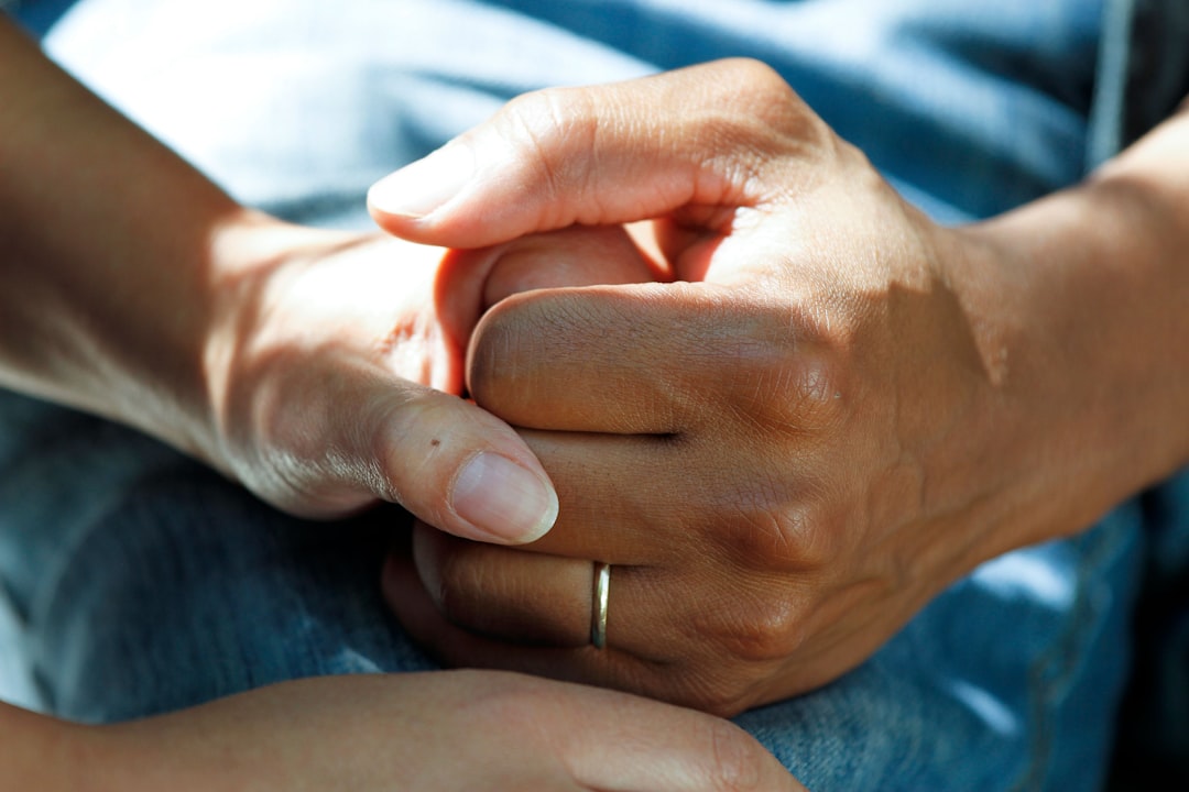 Two hands clasped together, symbolizing support and empathy.